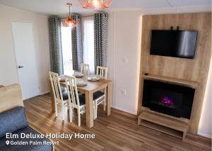 a living room with a table and a fireplace at Elm Deluxe Holiday Home in Chapel Saint Leonards