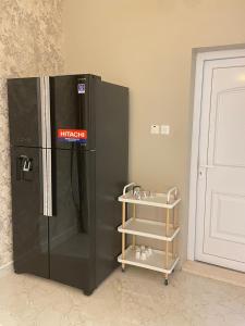 a black refrigerator with a shelf next to a door at مزرعه فلج المعلا in Falaj al Mu‘allá