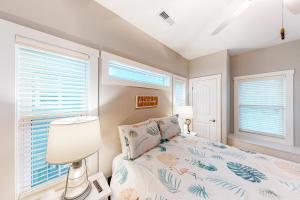 a bedroom with a bed and two windows at Sea N Red - upper in Oak Island