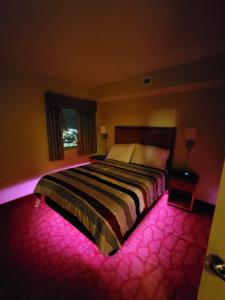 a bedroom with a large bed with pink lighting at Bayview Resort Penthouse w/ Sunset Views in Myrtle Beach