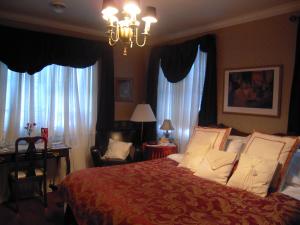 a bedroom with a large bed and a chandelier at L'Arvidienne Couette et Café in Quebec City