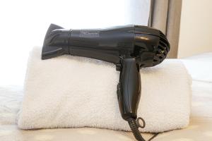 a black hair dryer sitting on a white rug at Alpha Properties 1 - Luxury One Bedroom within a Shared Four Bedroom House with Free Parking, Fast Wifi, SmartTV with Netflix in Milton Keynes