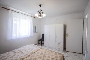 een slaapkamer met een bed, een raam en een stoel bij Apartment Tosca with Parking in Rovinj