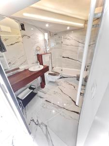 La salle de bains en marbre est pourvue d'un lavabo et de toilettes. dans l'établissement Fabulous Lakeside Family Apartment | 4 Rooms, à Montreux
