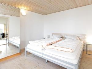 TogeholtにあるTwo-Bedroom Holiday home in Præstø 1の鏡付きの部屋の白いベッド1台