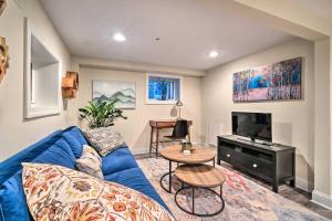 a living room with a blue couch and a tv at Washington DC Apartment at Rock Creek Park! in Washington, D.C.