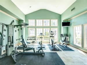 a gym with treadmills and ellipticals in a room at Dawn 722-Poolside Paradise in Galveston