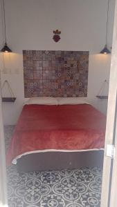 - une chambre avec un grand lit et une couverture rouge dans l'établissement PATIO Alojamiento, à San Miguel de Allende