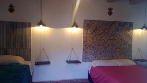 a bedroom with two beds and lights on the wall at PATIO Alojamiento in San Miguel de Allende
