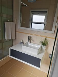 a bathroom with a white sink and a mirror at Casa da Alagoinha in Vila Nova de Milfontes