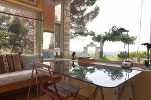 a room with a table and a couch and a large window at Mas de Baubesse: Paradise in Provence in Les Baux-de-Provence