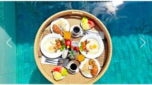 a round table with food and drinks in a swimming pool at One Bedroom Private Pool Kuta in Kuta