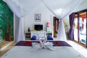 two white swans sitting on a bed in a bedroom at One Bedroom Private Pool Kuta in Kuta