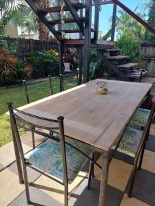 a wooden table and chair with a bowl on top at City centre, tropical home, minutes walk to shops. in Cairns