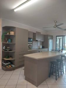 a kitchen with a large island with bar stools at City centre, tropical home, minutes walk to shops. in Cairns