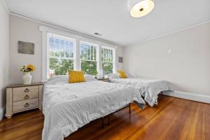 2 camas num quarto branco com pisos em madeira em Beautiful Historical home in Fisher Park! 4BR 3BA em Greensboro