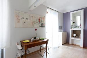 トリノにあるCit Ma Bel Studio Flatの白い壁の客室で、木製テーブルが備わります。