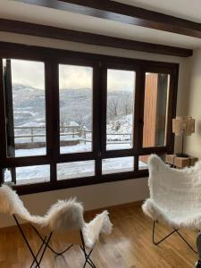 sala de estar con 2 sillas y ventana grande en Relax en el Pirineo, en Montanúy