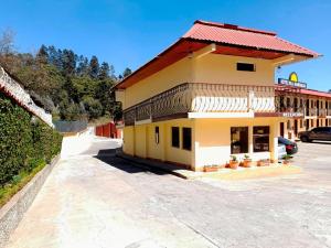 ein großes gelbes Gebäude mit rotem Dach in der Unterkunft Hotel y Restaurante Villa Esmeralda in Quetzaltenango