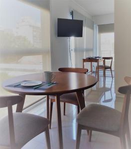 Blue Bird Studio Baires في بوينس آيرس: غرفة طعام مع طاولات وكراسي وتلفزيون