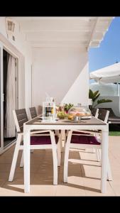 un tavolo da pranzo bianco con sedie in camera di The Little White House, Suite Flower Beach 9 a Playa Honda