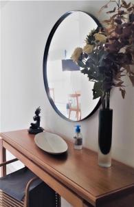 una mesa con espejo y un jarrón con flores en Blue Bird Studio Baires en Buenos Aires