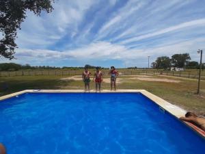three men standing on the edge of a blue swimming pool at Camino al Sol Domselaar wifi in Domselaar