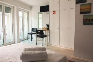 ein weißes Schlafzimmer mit einem Schreibtisch und einem Stuhl in der Unterkunft Hannah's Studios in Porto