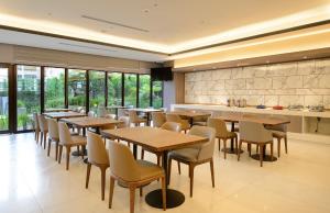 a restaurant with tables and chairs and a kitchen at Joyfultel in Guishan