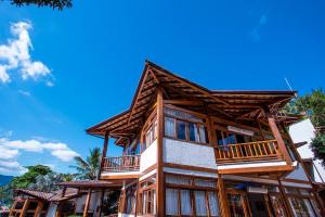 a large wooden building with a balcony on it at Hotel Praia do Portinho in Ilhabela