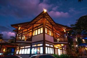 uma casa com um telhado de gambrel à noite em Hotel Praia do Portinho em Ilhabela