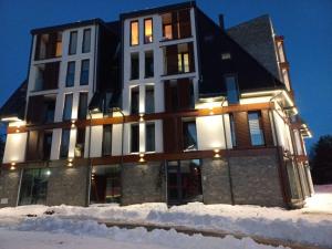 un grande edificio nella neve di notte di Borovi 24 a Divčibare