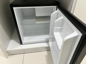 an empty white refrigerator with its door open at Aha Horizon Suites in Sepang