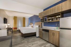 um quarto de hotel com uma cama e uma cozinha em MainStay Suites Joliet I-80 em Joliet