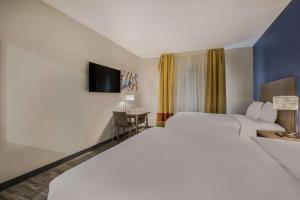 um quarto de hotel com uma cama grande e uma secretária em MainStay Suites Joliet I-80 em Joliet