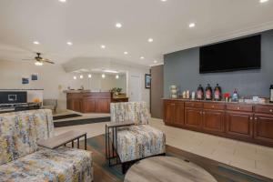 a living room with chairs and a flat screen tv at MainStay Suites Joliet I-80 in Joliet