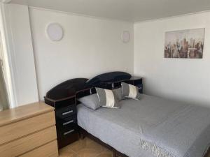 a bedroom with a bed with a wooden headboard and a dresser at Apartamento en Viña del Mar in Viña del Mar