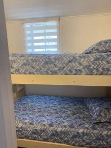 a bunk bed in a small room with a bed sqor at Apartamento en Viña del Mar in Viña del Mar