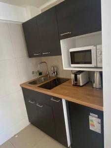 a kitchen with a sink and a microwave at Apartamento en Viña del Mar in Viña del Mar