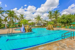 una piscina en un complejo con palmeras en Fairway Vista en Naples