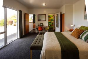 Habitación de hotel con cama grande y escritorio. en GLENALMOND Historic Homestead & Alpine Country Stay en Harihari