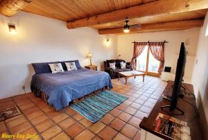 Sirena Vineyard Resort في باسو روبلز: غرفة نوم مع سرير وغرفة معيشة