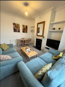 a living room with two blue couches and a table at Two Bedroom Apartment in London in London