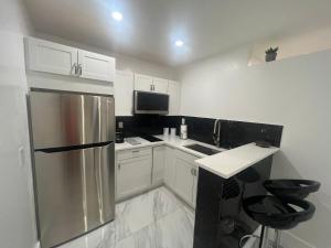 a kitchen with white cabinets and a stainless steel refrigerator at Villa San Carlos Park in Fort Myers