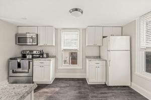 a kitchen with white cabinets and a white refrigerator at Family Friendly 2 Floor 2 BR Apt [Sunflower Stay] 