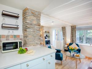 a kitchen and living room with a stone wall at Barley Cottage in Brownston