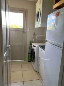 een keuken met een koelkast en een wasmachine bij 3 bedroom house in great location in Goondiwindi