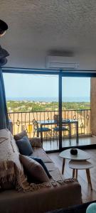 a living room with a couch and a view of a balcony at Casa Mar, studio 4P, vue mer, Sant'Ambroggio, Lumio in Lumio +11 photos