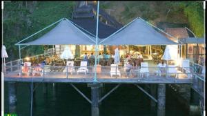 a dock with chairs and tables and umbrellas on the water at Sol Victoria Marina in Salvador