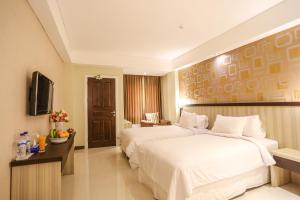 Un pat sau paturi într-o cameră la Sylvia Hotel Kupang